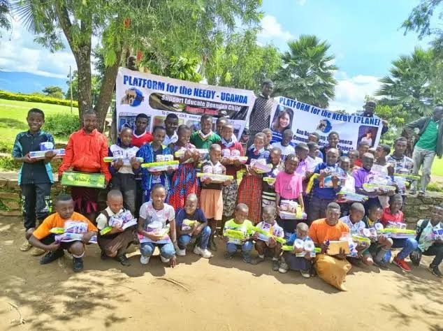 Assorted relief supply kits – medical boxes, hygiene packs, shelter tarpaulins, and water purification tablets arranged on a pallet, ready for distribution in Uganda.